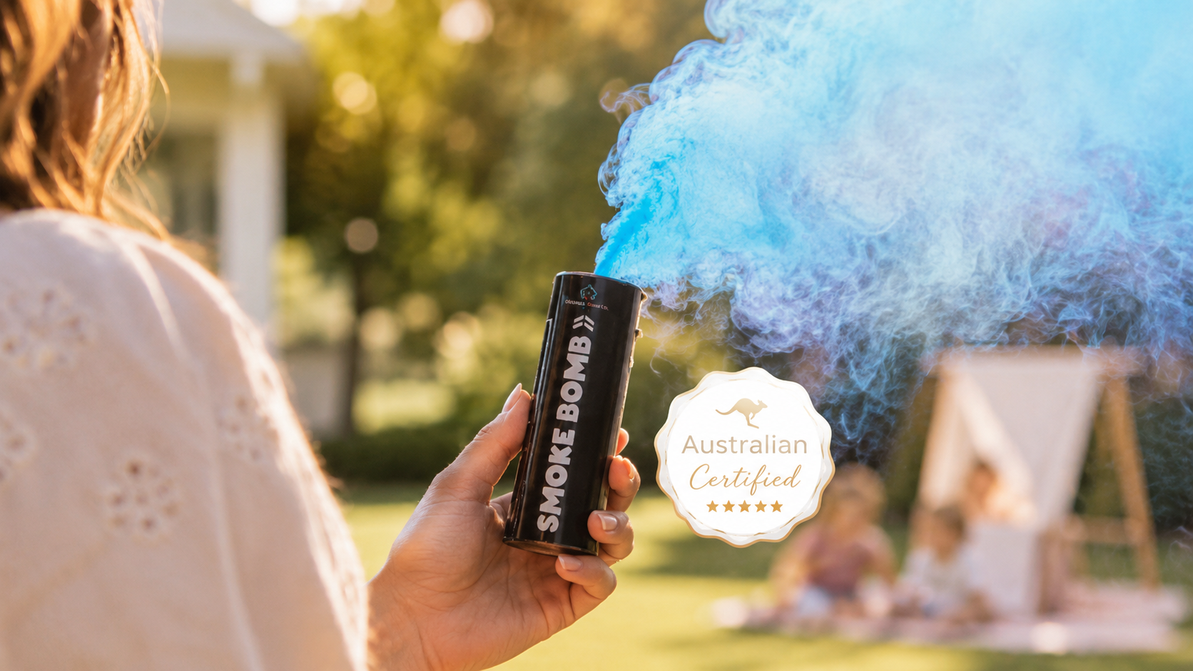An Australian mother holds a Gender Reveal Ideas branded smoke bomb at a backyard reveal, blue smoke trailing behind her, with the Australian Certified seal visible.